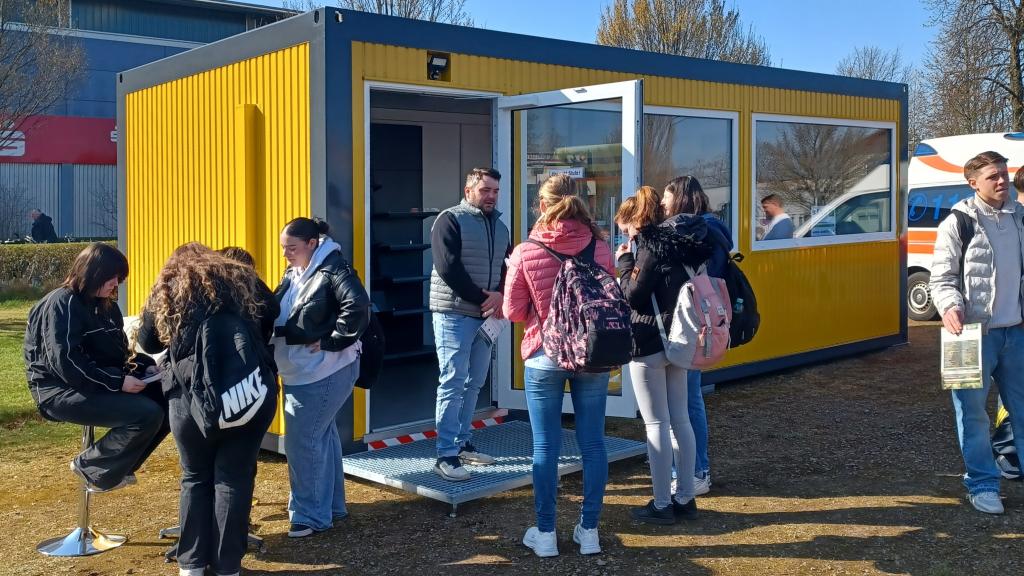 Besucher der Youlab informieren sich vor dem Ausstellungscontainer