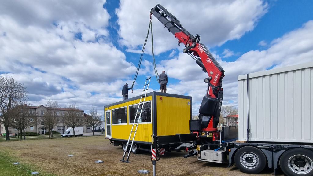 der SÄBU Container wird per Kran entladen auf dem Messegelände der Youlab