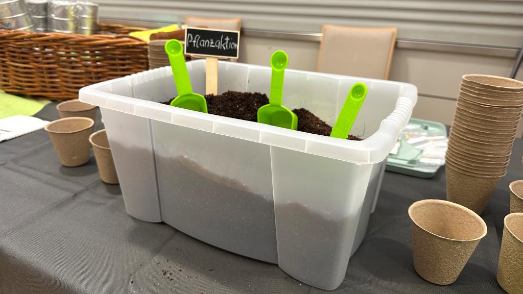 Die Utensilien für die Pflanzaktion sind Erde, kleine Schaufeln, Pflanzbecher und Blumen- und Gemüsesamen