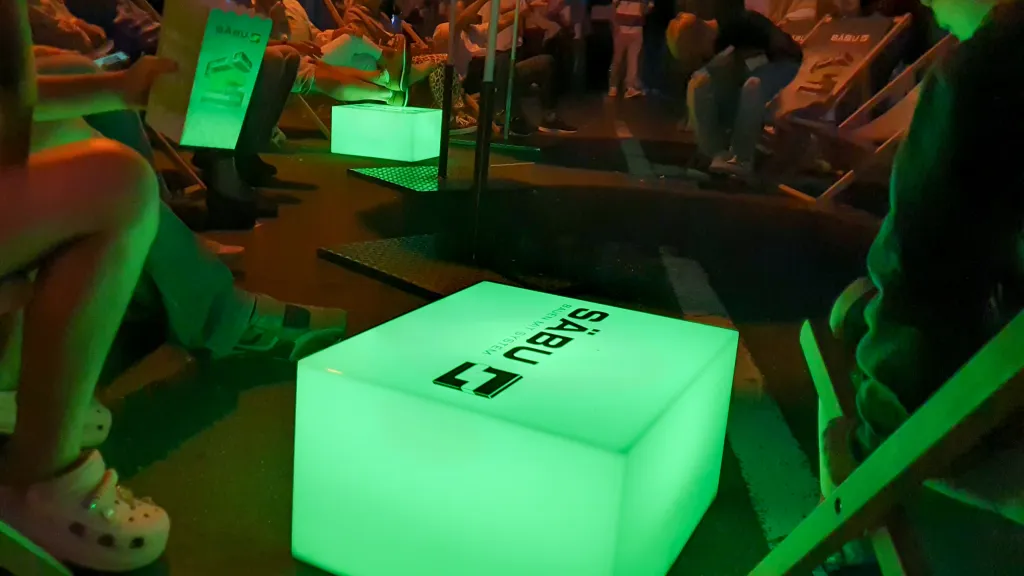 Abendstimmung auf einem Event mit Menschen, die auf Liegestühlen sitzen.