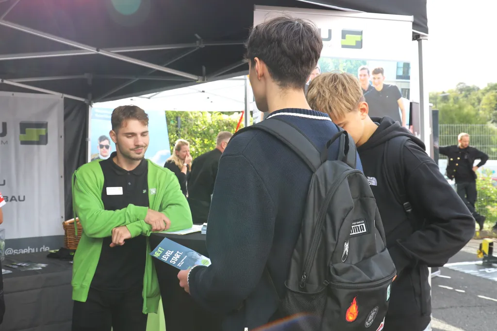 Ein Blick auf den Azubi in einem netten Gespräch mit zwei Schüler an unserem SÄBU stand